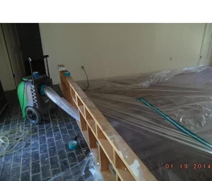 air mover drying out hardwood floor covered in protective plastic in Memphis, TN