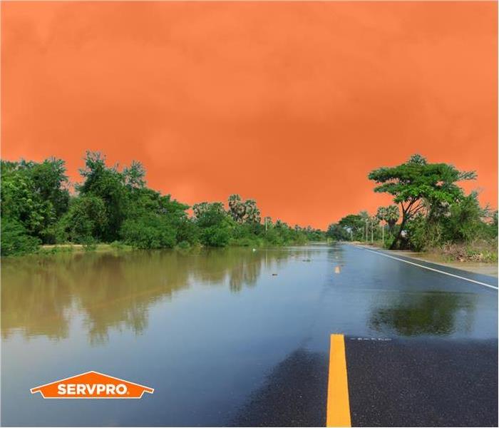 flood water over a road in Southeast Memphis, bright orange sky, SERVPRO logo